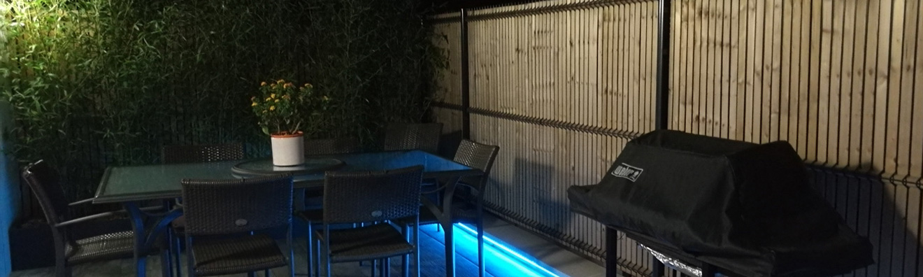 Une terrasse très tendance où bois et led se mélangent autour d'un panneau Nylofor 3D